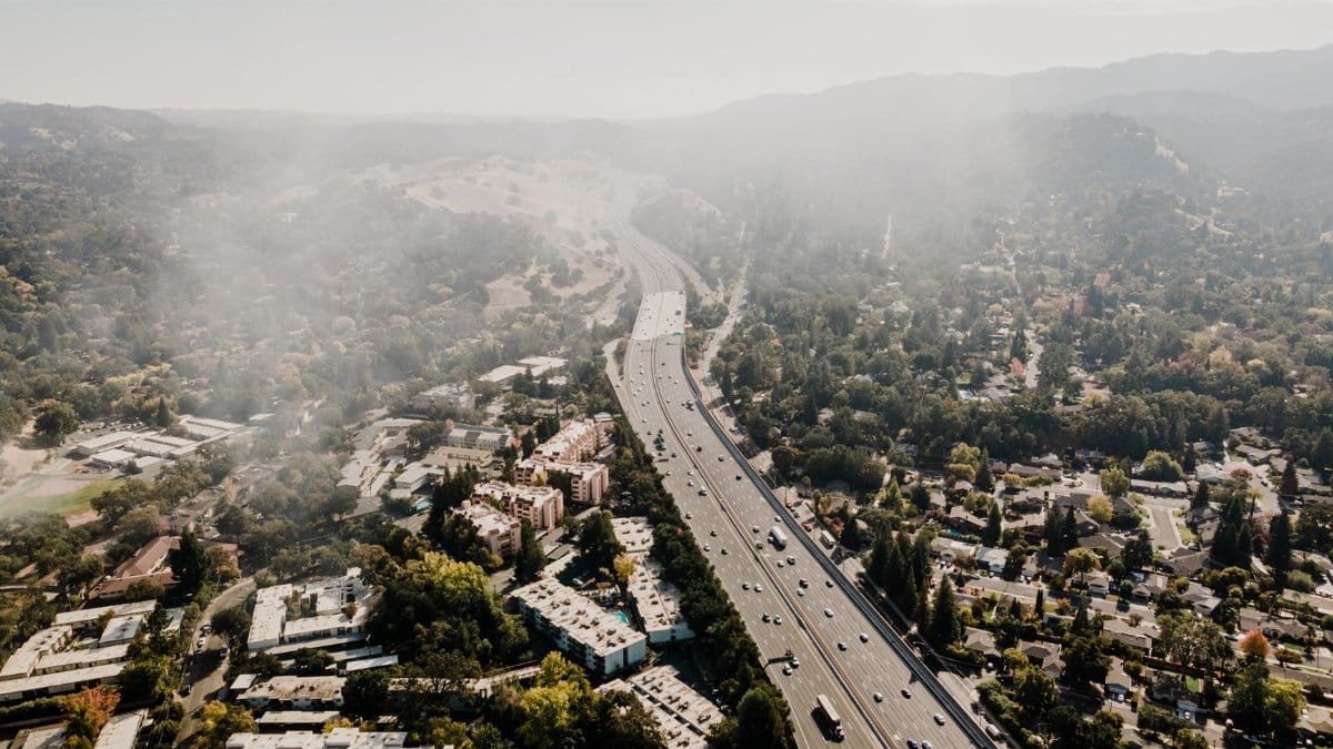 Aerial view of freeway and suburbs in Walnut Creek, CA, under misty skies.