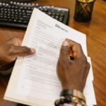 A person signs official divorce documents at an office desk.