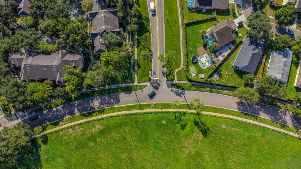 Aerial shot of a suburban neighborhood in Florida, showcasing roads, homes, and greenery.
