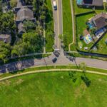 Aerial shot of a suburban neighborhood in Florida, showcasing roads, homes, and greenery.