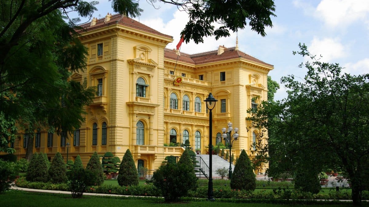 A stunning view of the Presidential Palace in Hanoi surrounded by lush garden greenery.