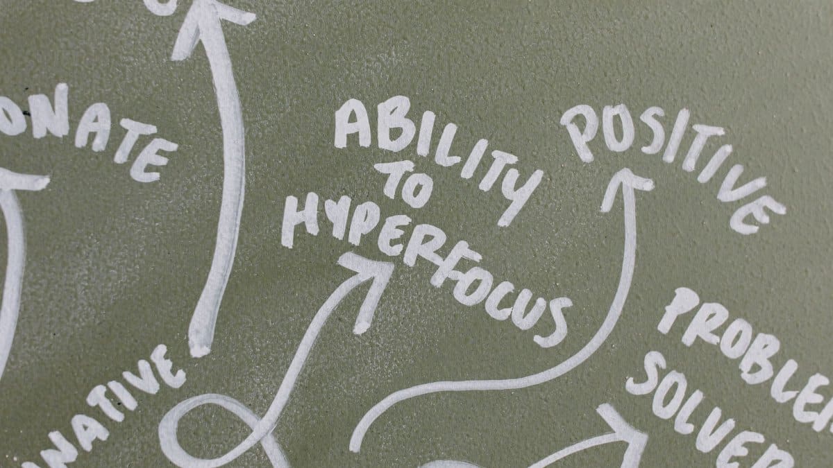 Mind map on chalkboard highlighting positive traits like hyperfocus, creativity, and problem-solving.