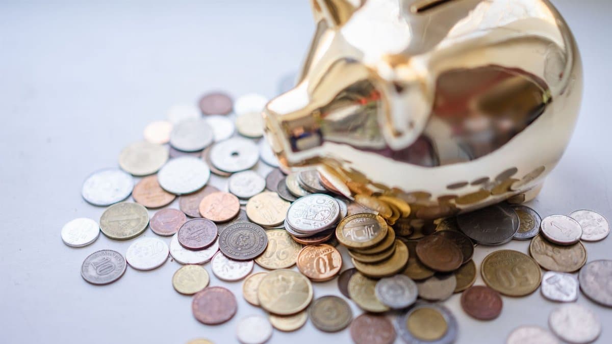 A golden piggy bank surrounded by assorted coins, symbolizing savings and wealth.
