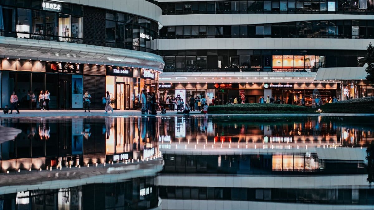 Reflective view of bustling modern architecture in Beijing, capturing urban life at night.