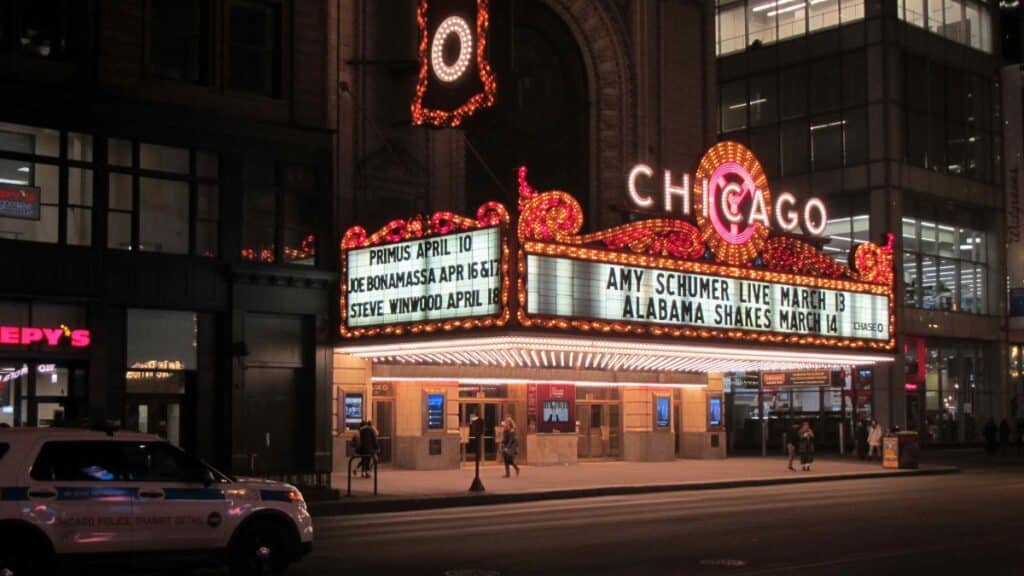 Night view of the Chicago Theater with illuminated marquee signs in downtown Chicago.