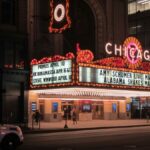 Night view of the Chicago Theater with illuminated marquee signs in downtown Chicago.
