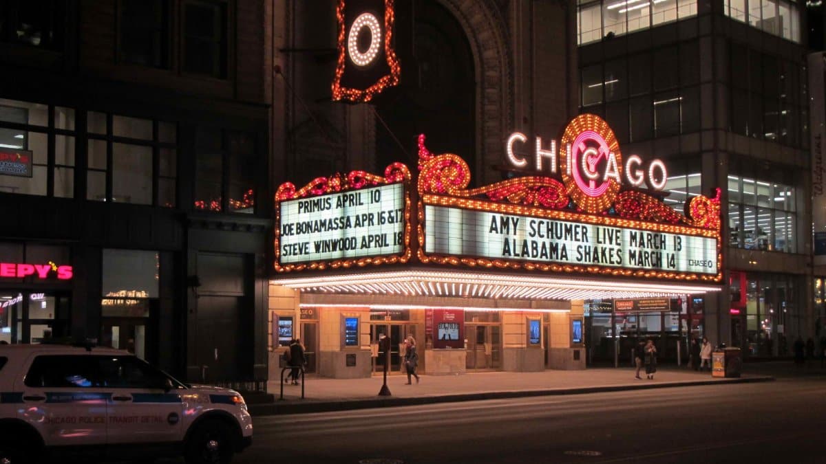 Night view of the Chicago Theater with illuminated marquee signs in downtown Chicago.