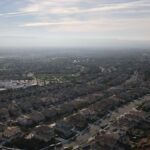 Bird's eye view of a suburban residential area in Dublin, CA with a clear sky and distant hills.