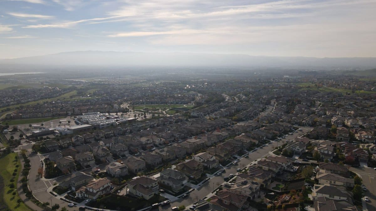 Bird's eye view of a suburban residential area in Dublin, CA with a clear sky and distant hills.