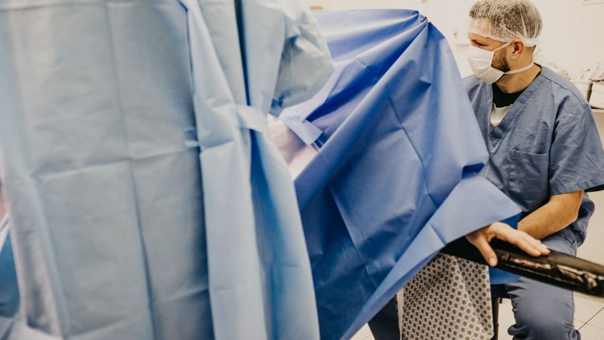 Healthcare professional in a delivery room, ready for surgery, illustrating a medical setup.