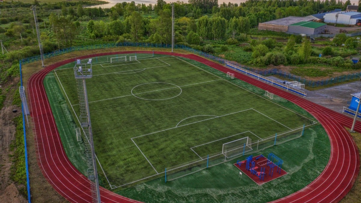 Aerial view of a vibrant sports complex including a football field and surrounding track.