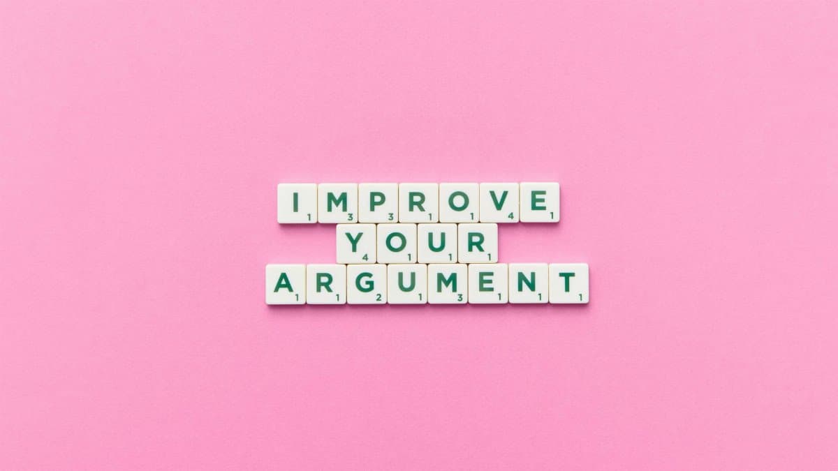 Scrabble tile letters spelling 'Improve Your Argument' on a pink background.