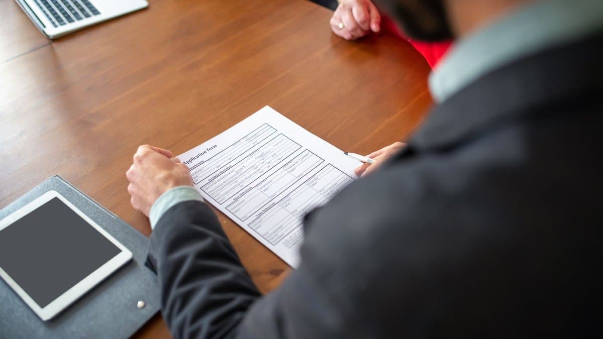 Business professionals reviewing an application form during a meeting.