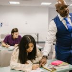 Teacher monitors students during an exam in a classroom, emphasizing academic integrity.