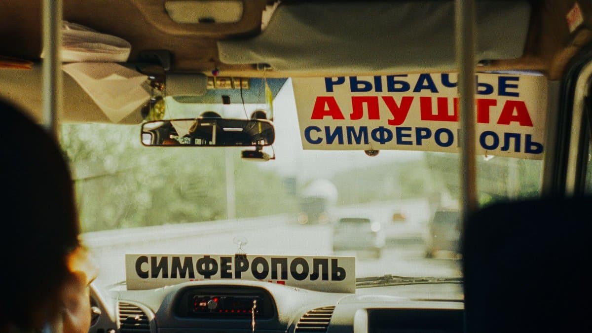 View from inside a local Crimean van showing a sign for Simferopol and Alushta destinations.