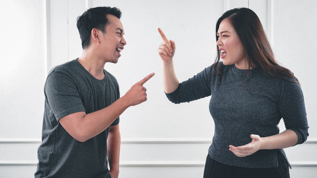 A couple engaged in a heated argument at home, expressing strong emotions.