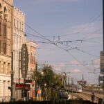 Street scene in downtown Houston featuring historic buildings and a train under a clear blue sky.