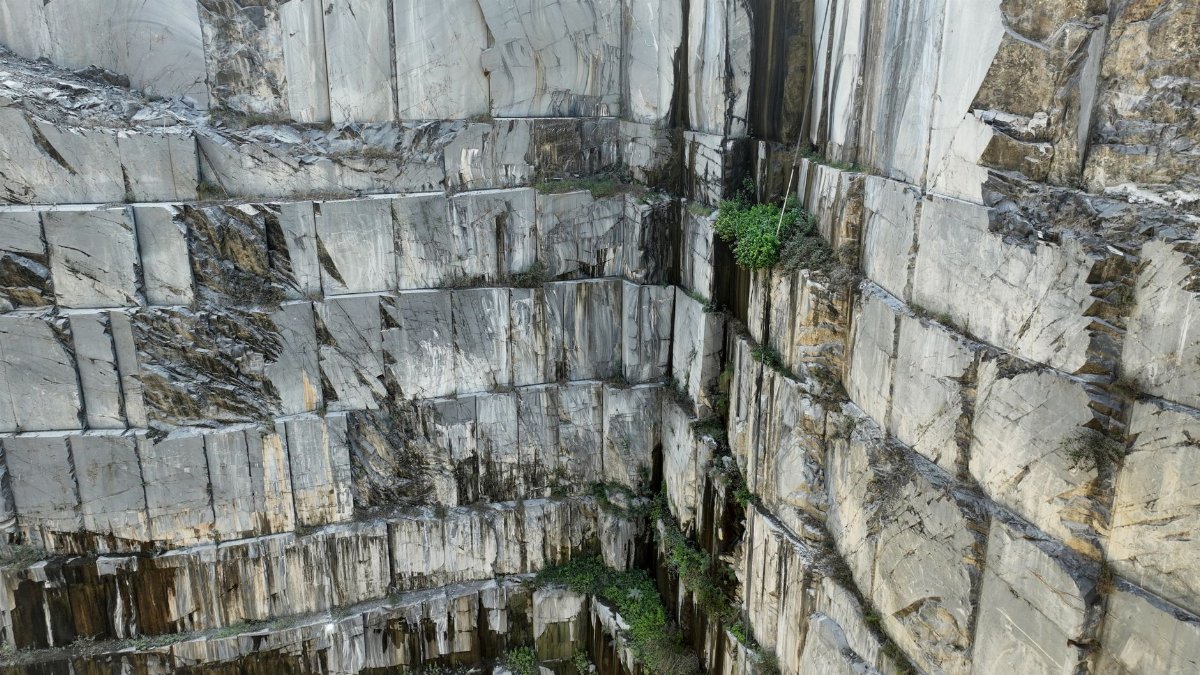 Detailed view of a granite quarry with visible stone blocks and greenery.