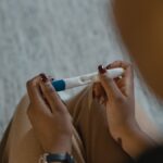 Close-up of a woman holding a positive pregnancy test with a plus sign, symbolizing new beginnings.