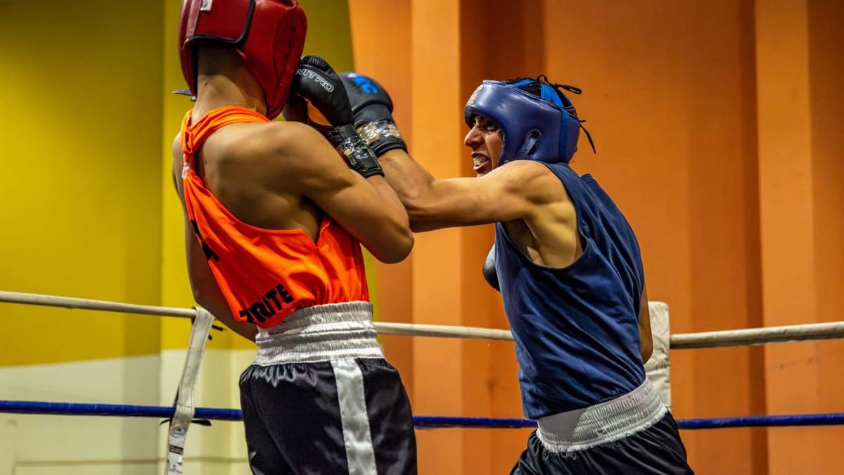 Two young athletes spar inside a boxing ring, showcasing skill and determination.