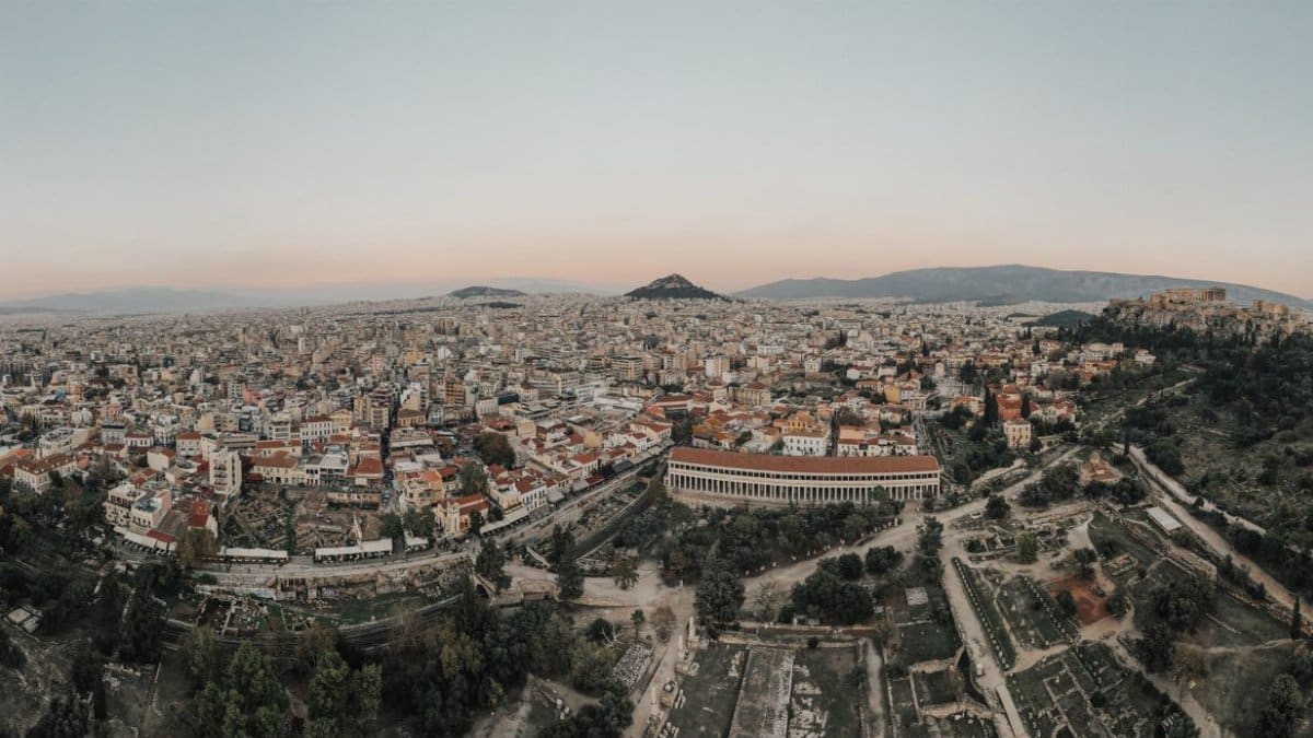 A stunning aerial view of Athens cityscape at sunrise, showcasing historical landmarks.