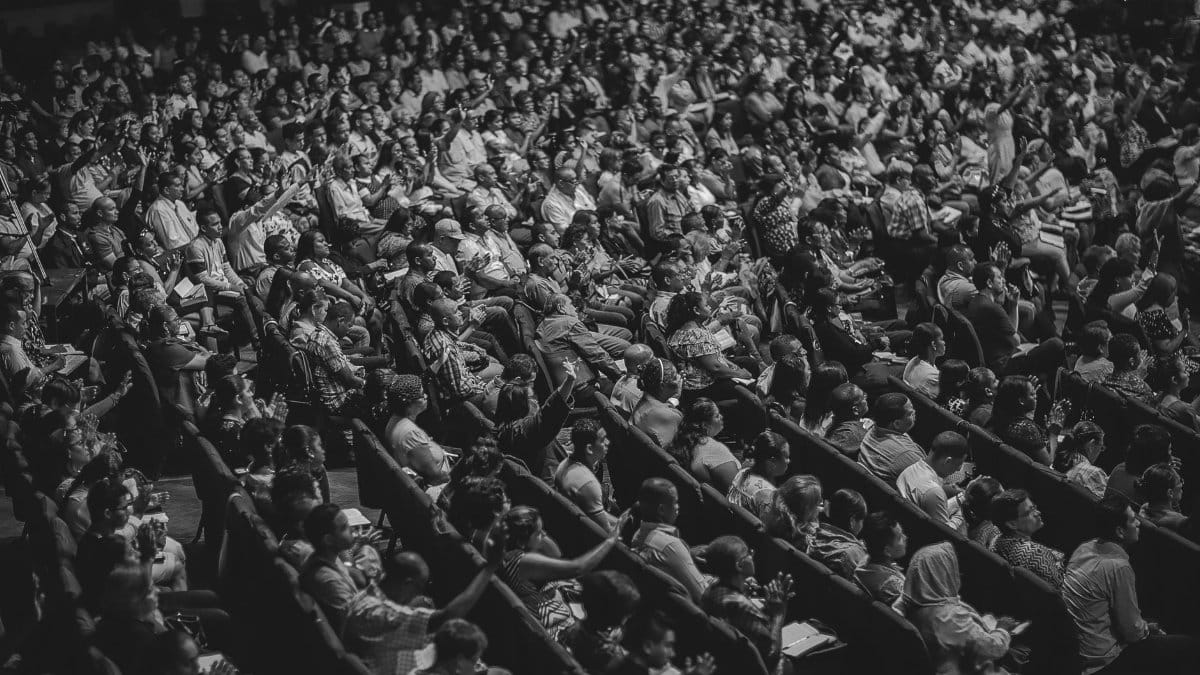 High angle view of a diverse audience in a theater setting, captured in monochrome.