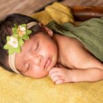 Charming photo of a newborn baby peacefully sleeping with a floral headband. Perfect for baby-related content.