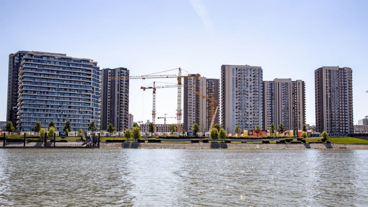 Modern buildings and cranes by the river in Belgrade, Serbia showcase urban development.