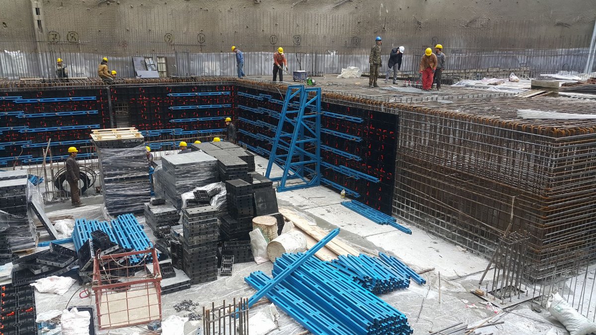 Workers at a Tehran construction site using formwork. Urban development scene.