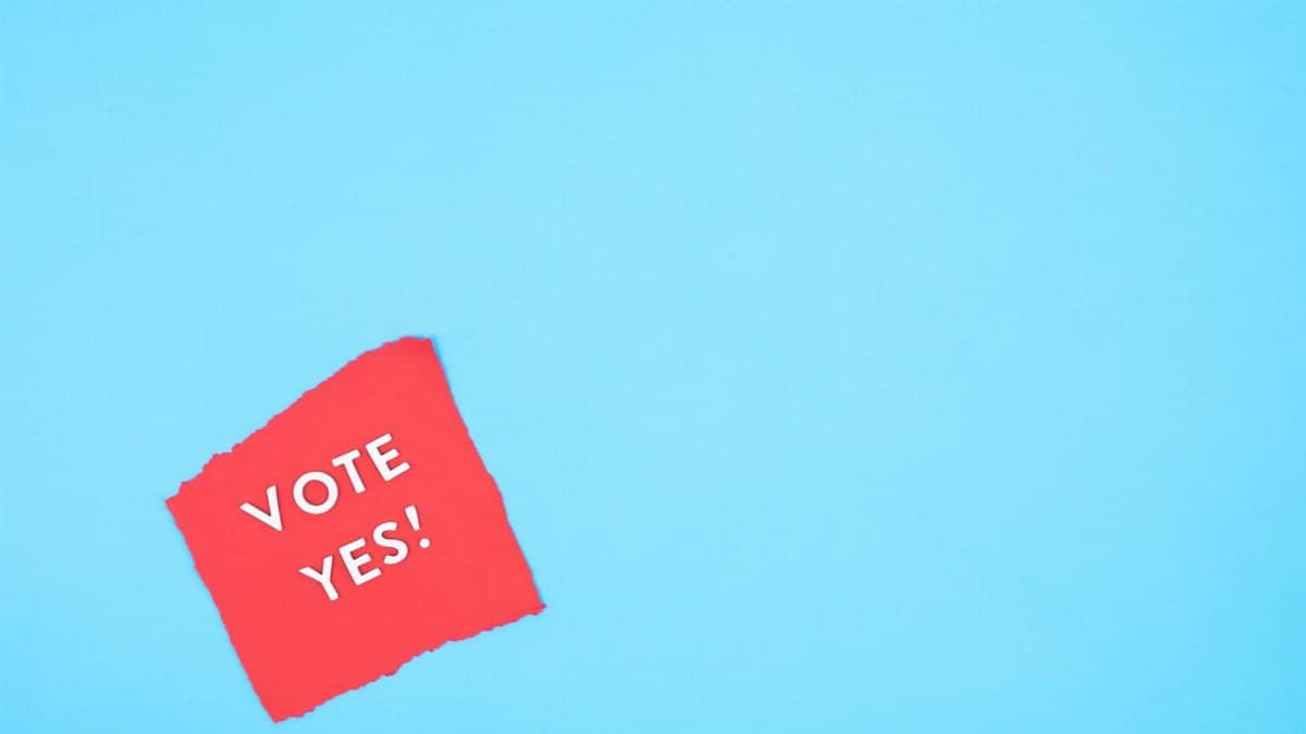 Red paper with 'Vote Yes!' text on a bright blue background promoting positive political engagement.