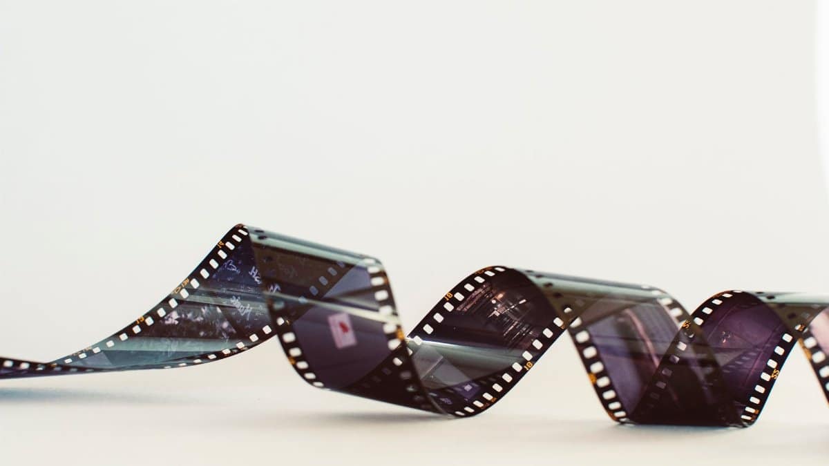 Close-up of a classic photographic film strip with a vintage feel against a white background.