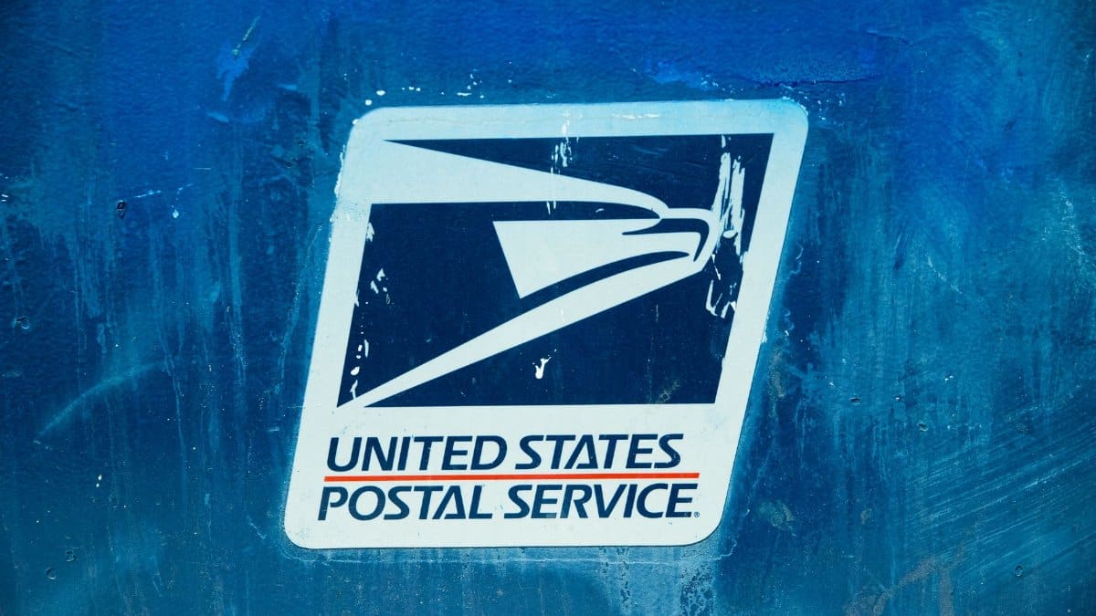 Detailed view of the United States Postal Service logo on a blue background, showcasing texture.