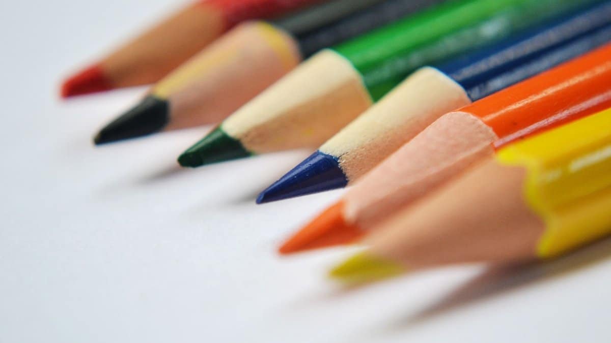 Vibrant macro shot of colorful, sharpened pencils arranged diagonally on a white background.