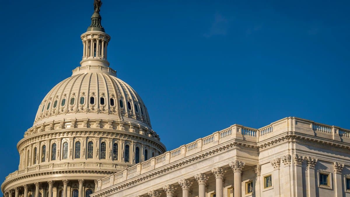The iconic dome of the United States Capitol against a clear blue sky, showcasing its classical architecture.