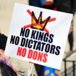 Protesters in Baltimore hold signs against dictatorial rule during a demonstration.