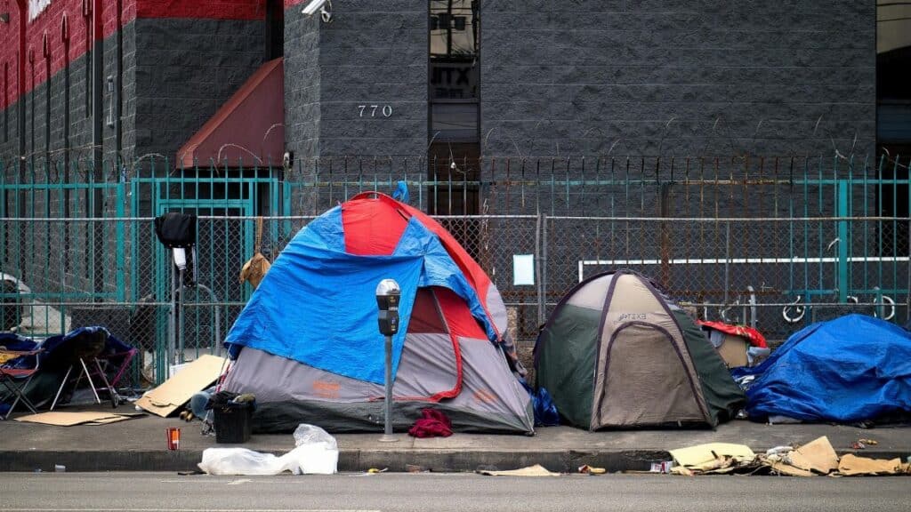 A view of tents set up on a sidewalk in Los Angeles, representing urban homelessness.