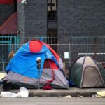 A view of tents set up on a sidewalk in Los Angeles, representing urban homelessness.