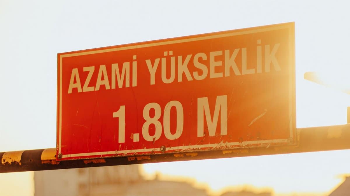 A red maximum height sign with sunlight in the background, reading 'Azami Yukseklik 1.80 M'.