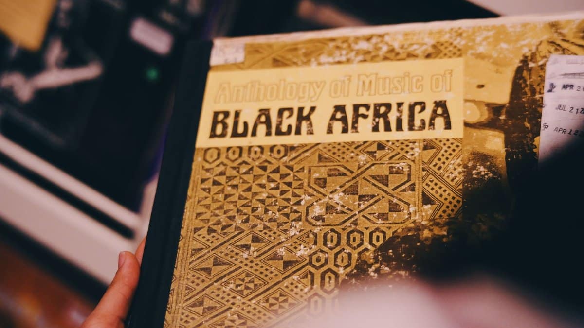Vintage album cover titled 'Anthology of Music of Black Africa,' held by a hand, showcasing intricate designs.