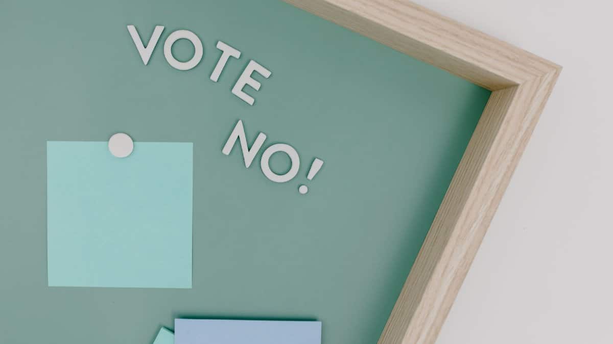Creative conceptual image of a framed 'Vote No' sign on a green board.