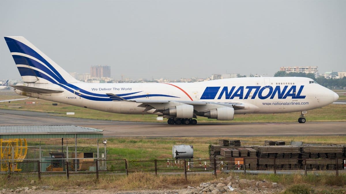 National Airlines Boeing 747 taxiing on runway at airport, daytime view.