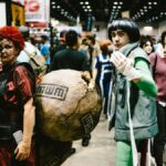 Cosplayers dressed as anime characters at a bustling convention center.
