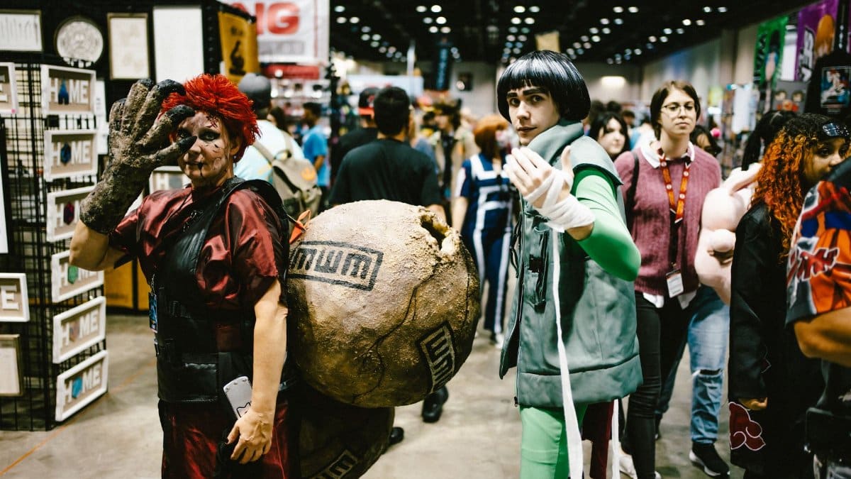 Cosplayers dressed as anime characters at a bustling convention center.
