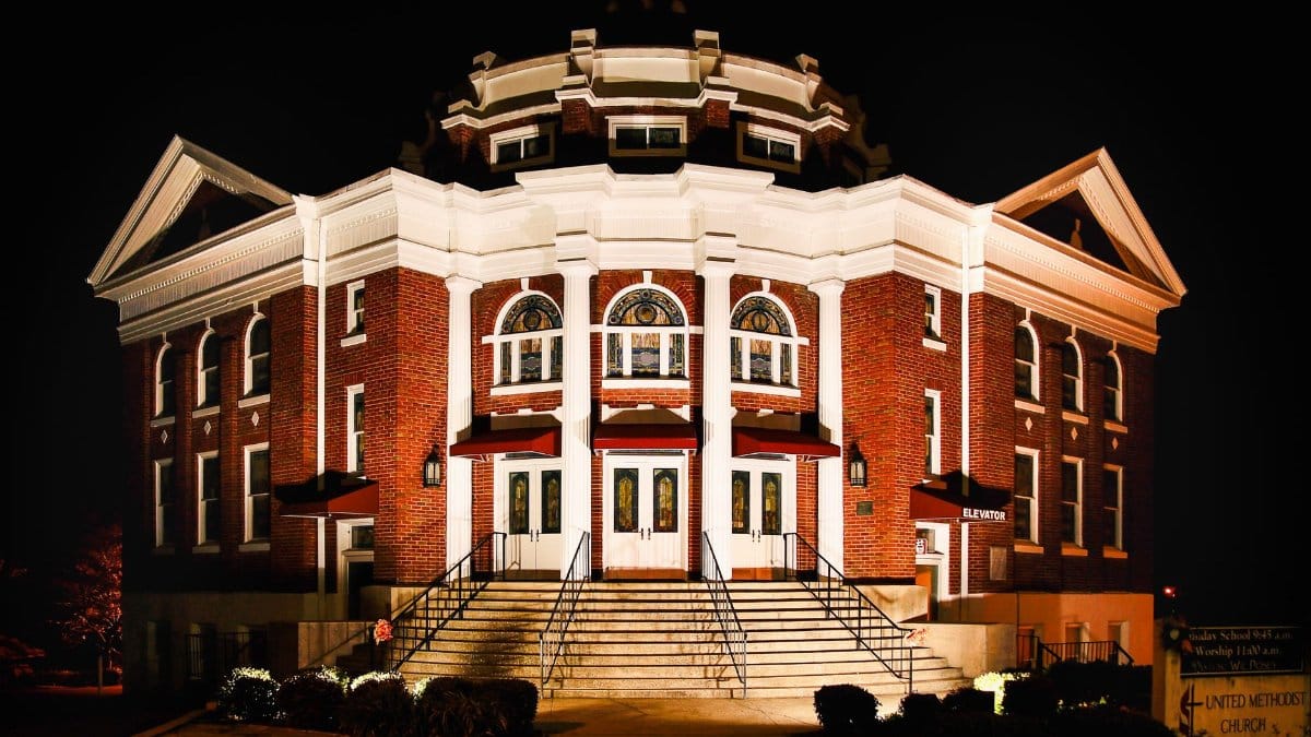 Illuminated facade of First United Methodist Church in Murphy, NC at night.