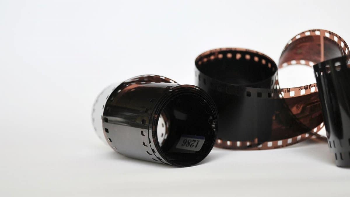 Two vintage photo film reels against a white backdrop, showcasing analog photography equipment.