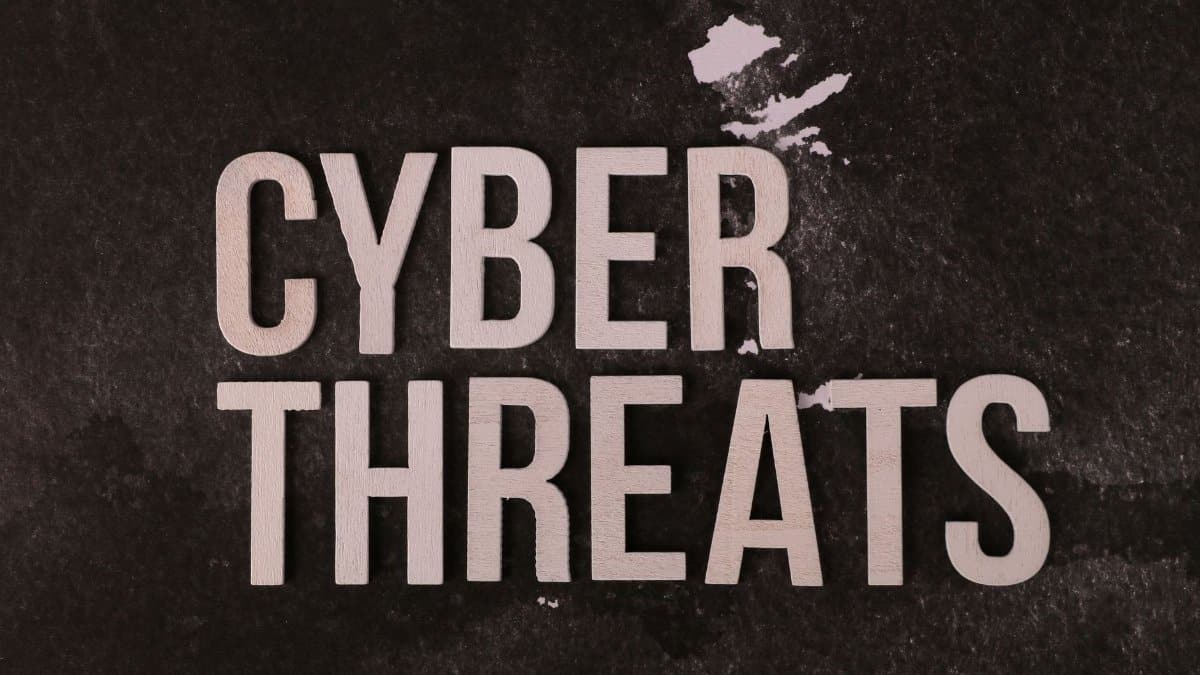 The phrase 'Cyber Threats' displayed on a textured dark background, emphasizing digital security.