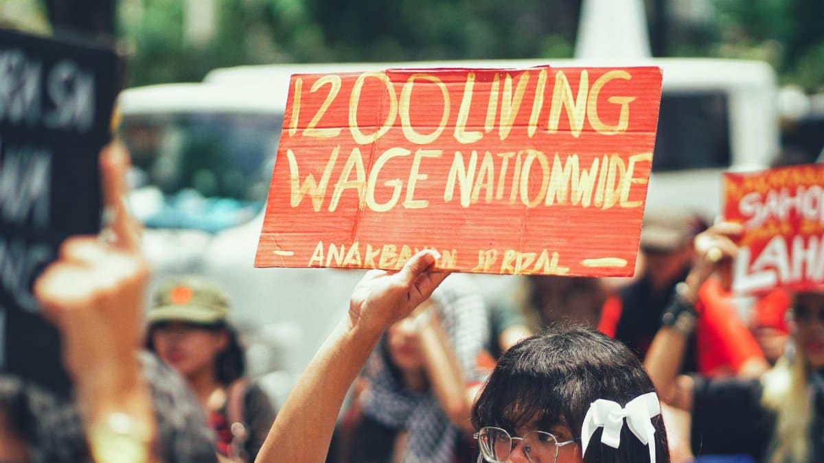 A group of protestors holding a sign demanding a 1200 living wage nationwide.