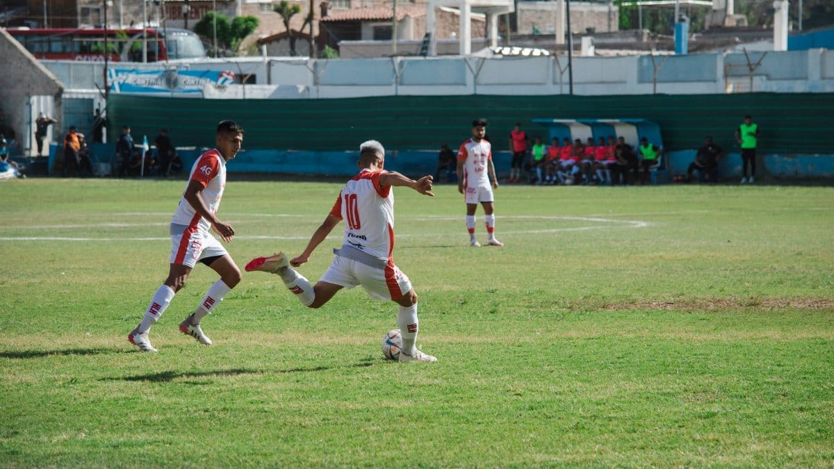 Intense soccer game in Mina, Mendoza, Argentina showcasing teamwork and action on a sunny day.