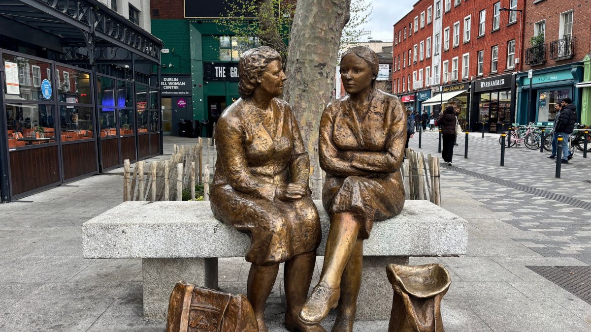 Bronze sculptures of women on a Dublin street bench showcasing urban art.