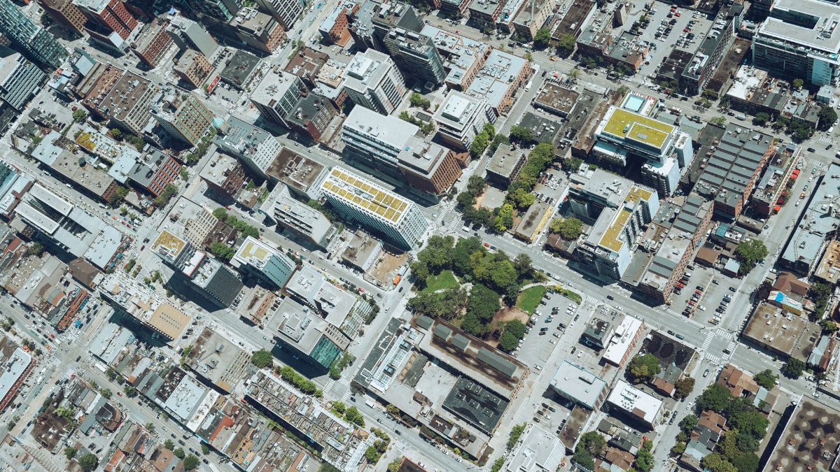 Drone view of city district with typical contemporary building and streets on sunny day